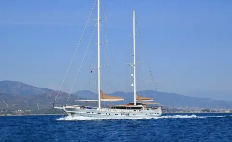 Queen Of Salmakis yacht sailing on calm blue sea at sunset