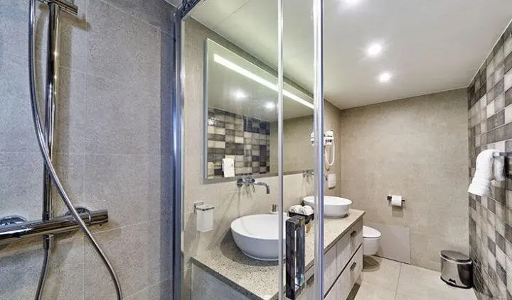 Dalmatino cabin interior with dual vessel-sink vanity and glass shower enclosure