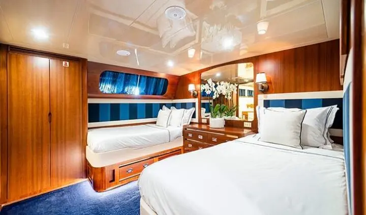 Interior of Wind Of Fortune twin cabin: wood paneling, beds, and seating area