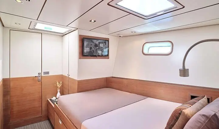 Two-bed cabin aboard Aizu yacht with porthole window and wood trim