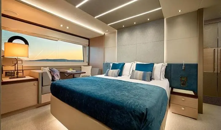 Master cabin with king bed, blue bedding, ensuite door, ambient lighting