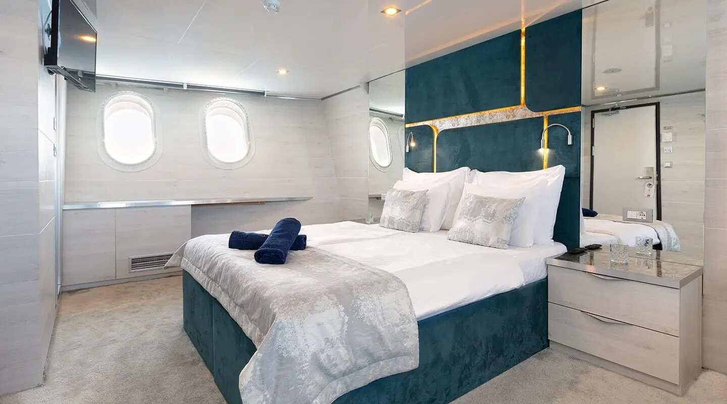Yacht Yolo bedroom interior with white and teal bedding and pillows