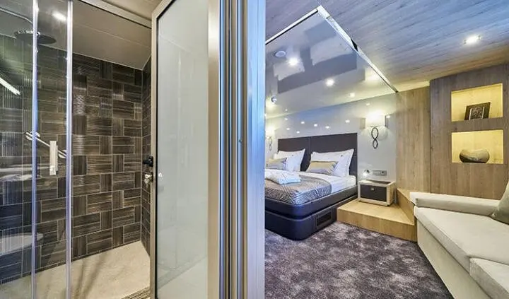 Dalmatino master cabin with king bed and ensuite bathroom, stylish wood and soft lighting