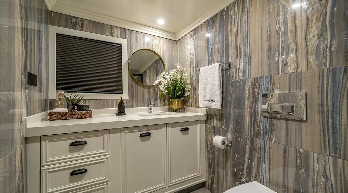 Queen Of Makri yacht interior with a kitchenette and floral decor at dusk