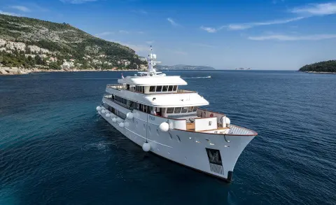 Yolo luxury yacht sailing on blue sea near coastline at sunset, multiple decks