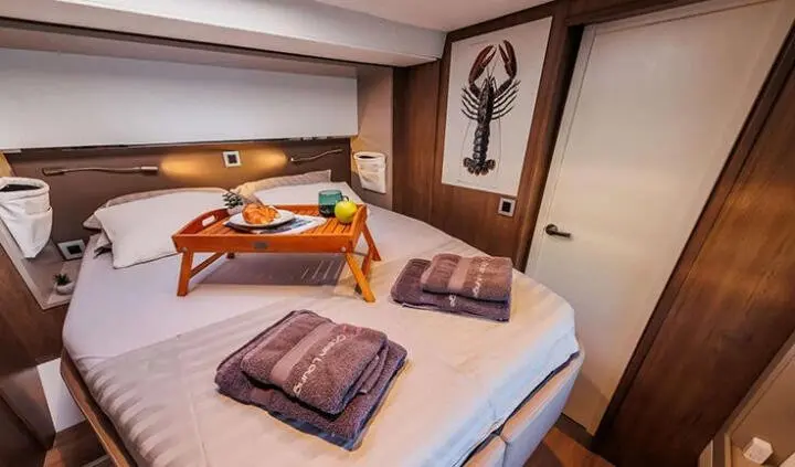 Double-cabin ocean lounge aboard yacht with neatly made bed and towels