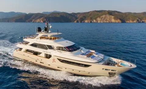 Takara One luxury motor yacht anchored near rocky coastline at dusk