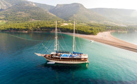 Tajna Mora sailing yacht anchored near a sandy cove with turquoise waters