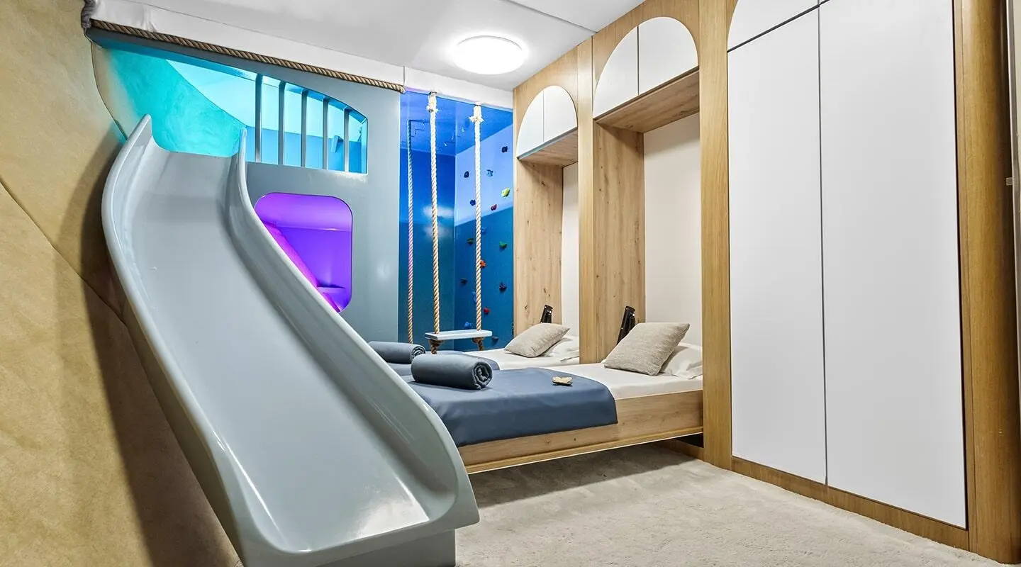 Interior shot of Bella yacht playroom with seating, ladder, and large windows