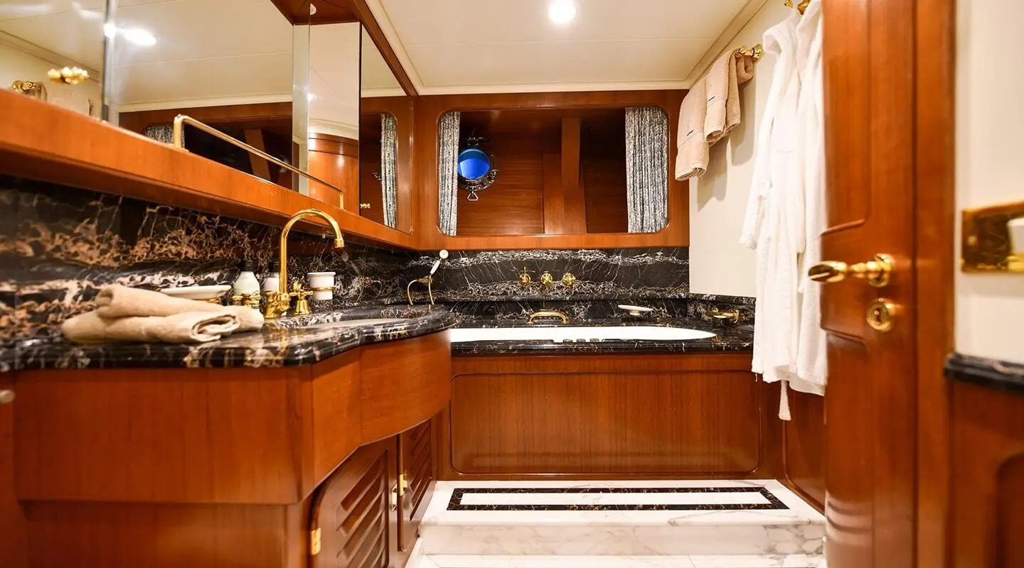 Luxurious yacht bathroom with marble surfaces and wooden cabinetry