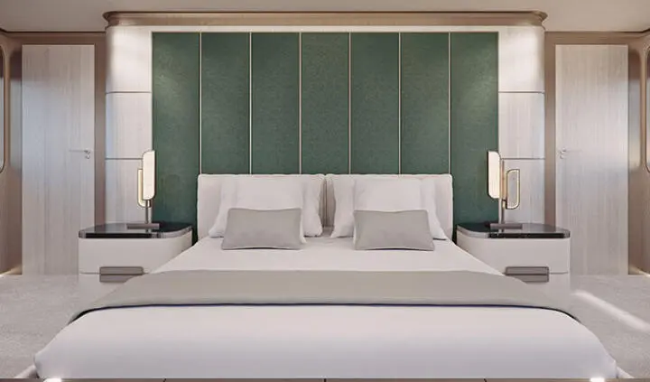Maia yacht master cabin with king bed, neutral bedding, green padded headboard