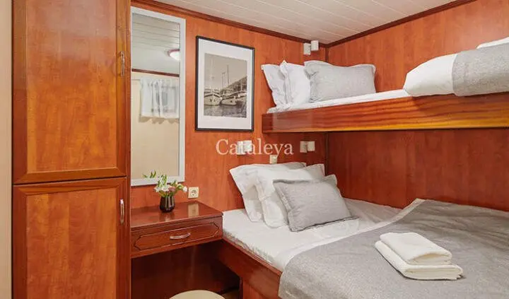 Twin cabin interior on Cataleya yacht with two single beds and wooden walls