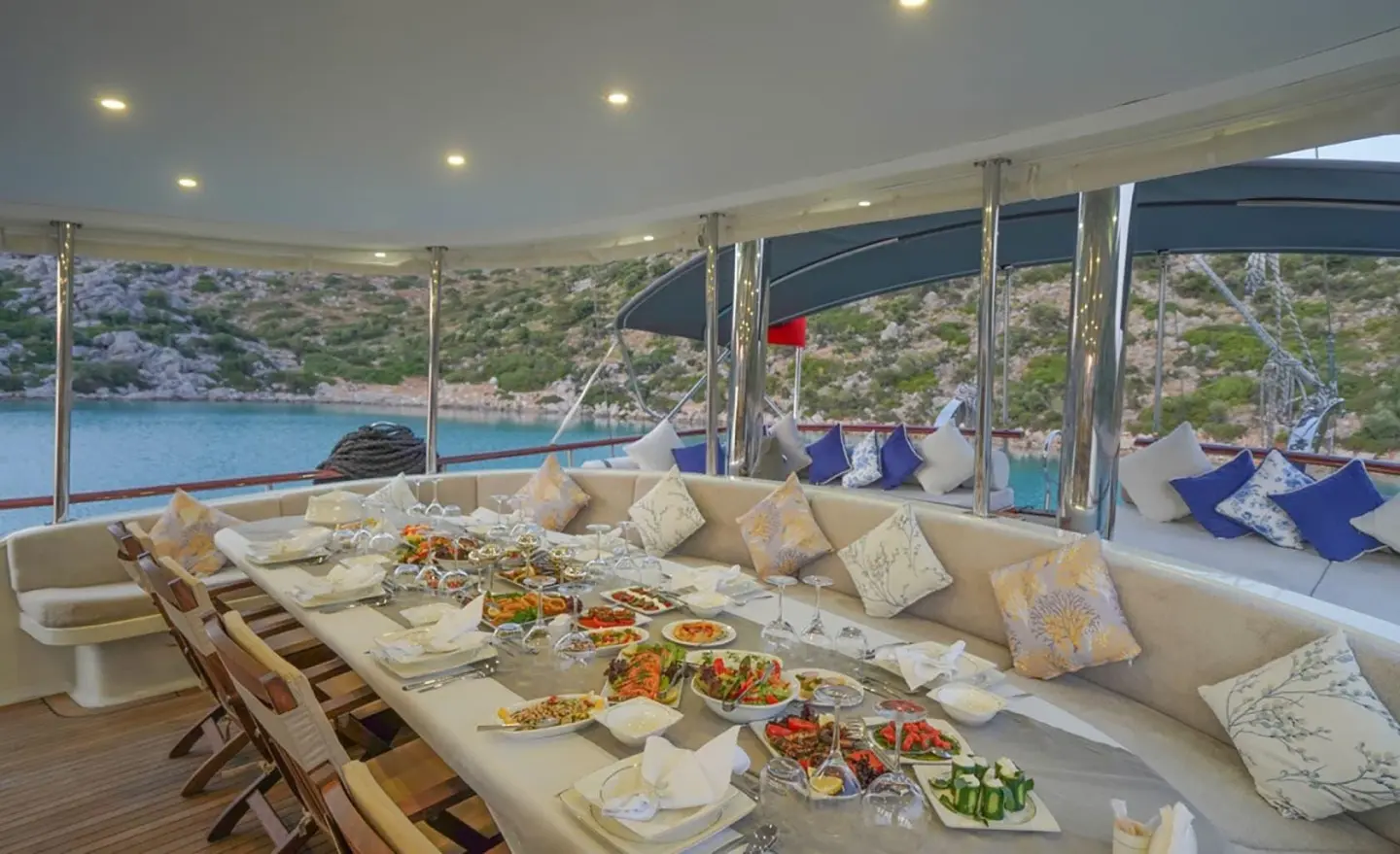 Prenses Esila yacht dining area with long table set for guests aboard at sunset