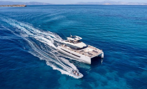 White motor yacht cruising on blue sea with wake behind it