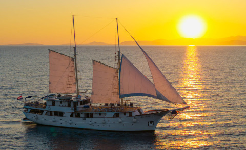 Mendula sailing yacht under sunset with white hull and sails in golden light