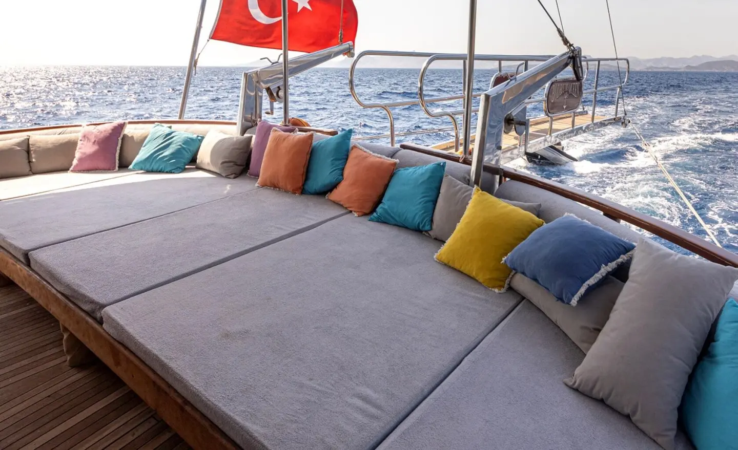 Yacht Bodrum Queen deck seating with colorful cushions and Turkish flag