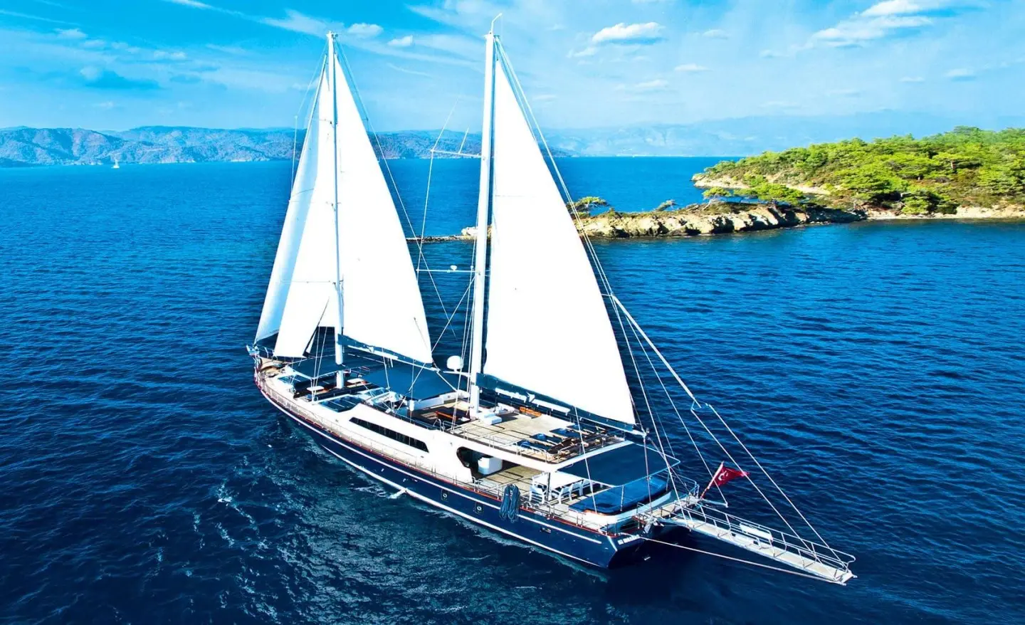 Maske 2 sailing yacht with two white sails cutting through blue sea