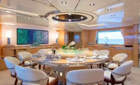 O'Natalina motor yacht interior with polished wood dining area and overhead lighting