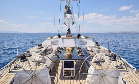 Aizu yacht deck with a dining table set against the sea