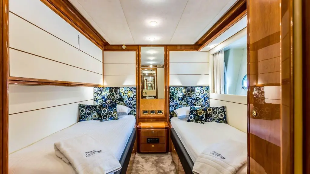 Miss Katariina yacht interior with two beds, wooden cabinet, and porthole