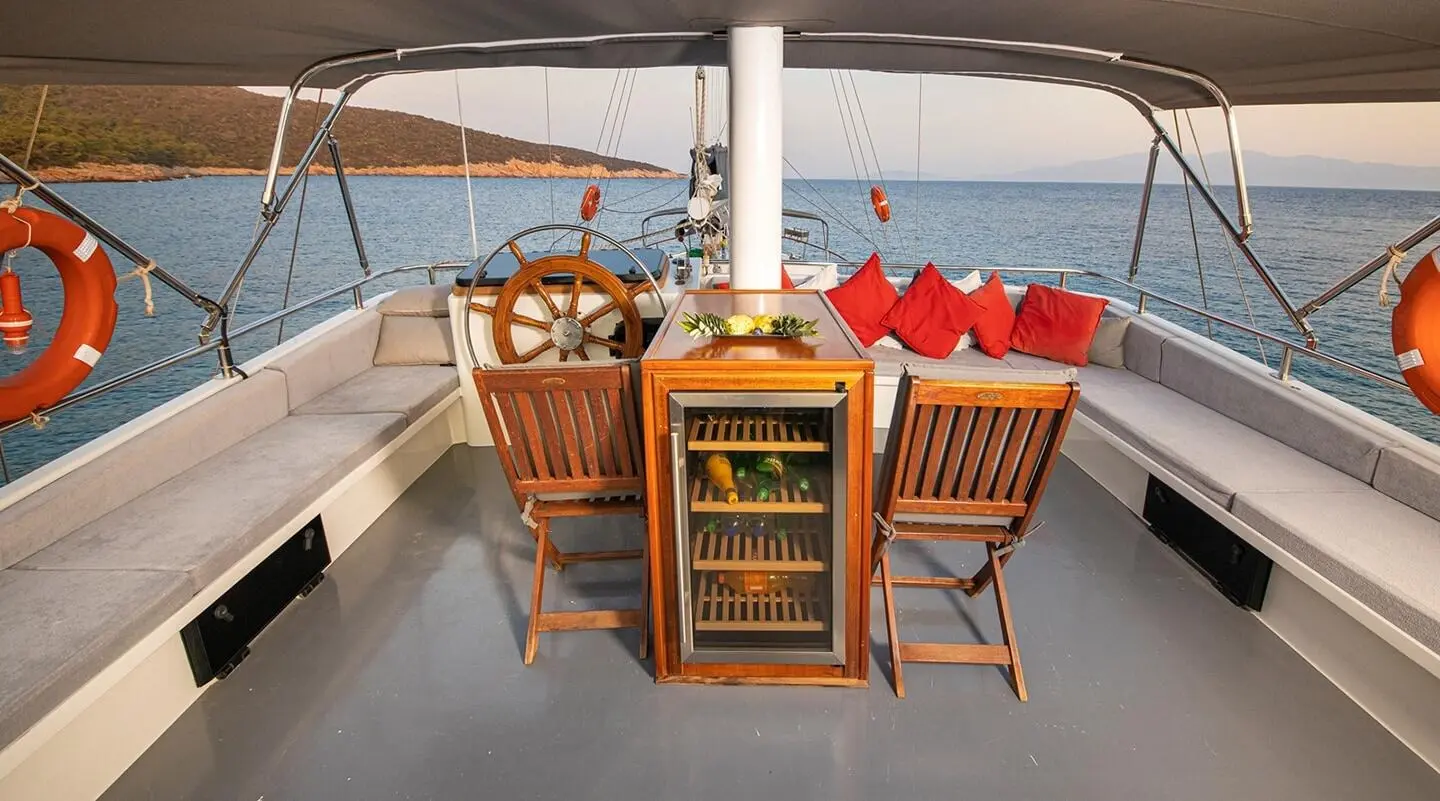 Bodrum Queen sunset cockpit with wooden helm, seating & drinks fridge on deck