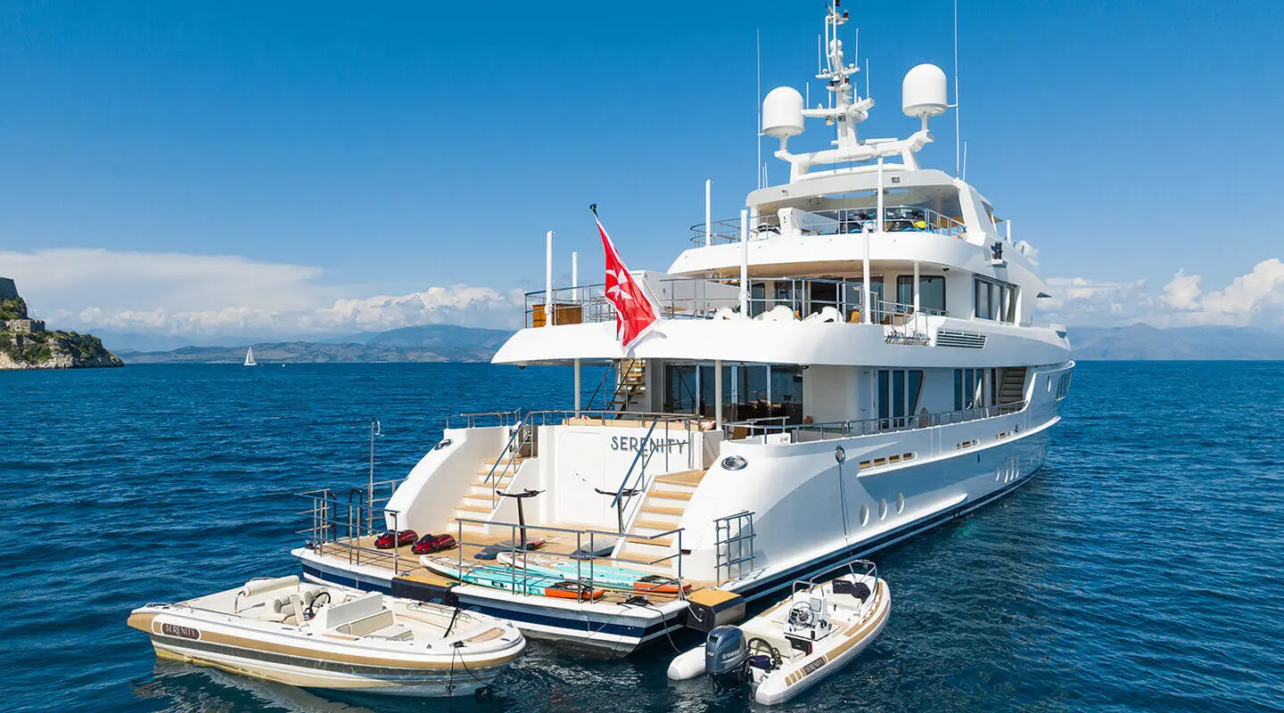 White motor yacht Serenity with dinghies beside stern and open deck