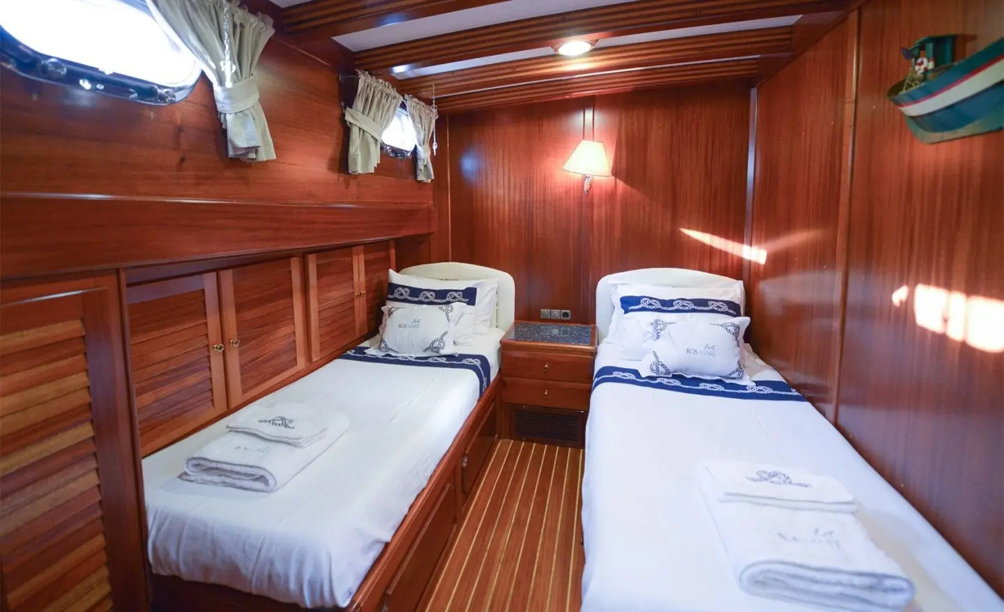 Interior of gulet Ros Mare with twin cabins, wooden walls, two single beds