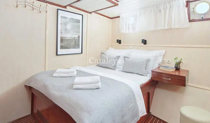 Two single beds in a cabin with white linens and wooden accents