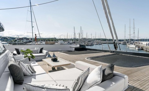 White outdoor seating area and cushions on wooden deck on a yacht