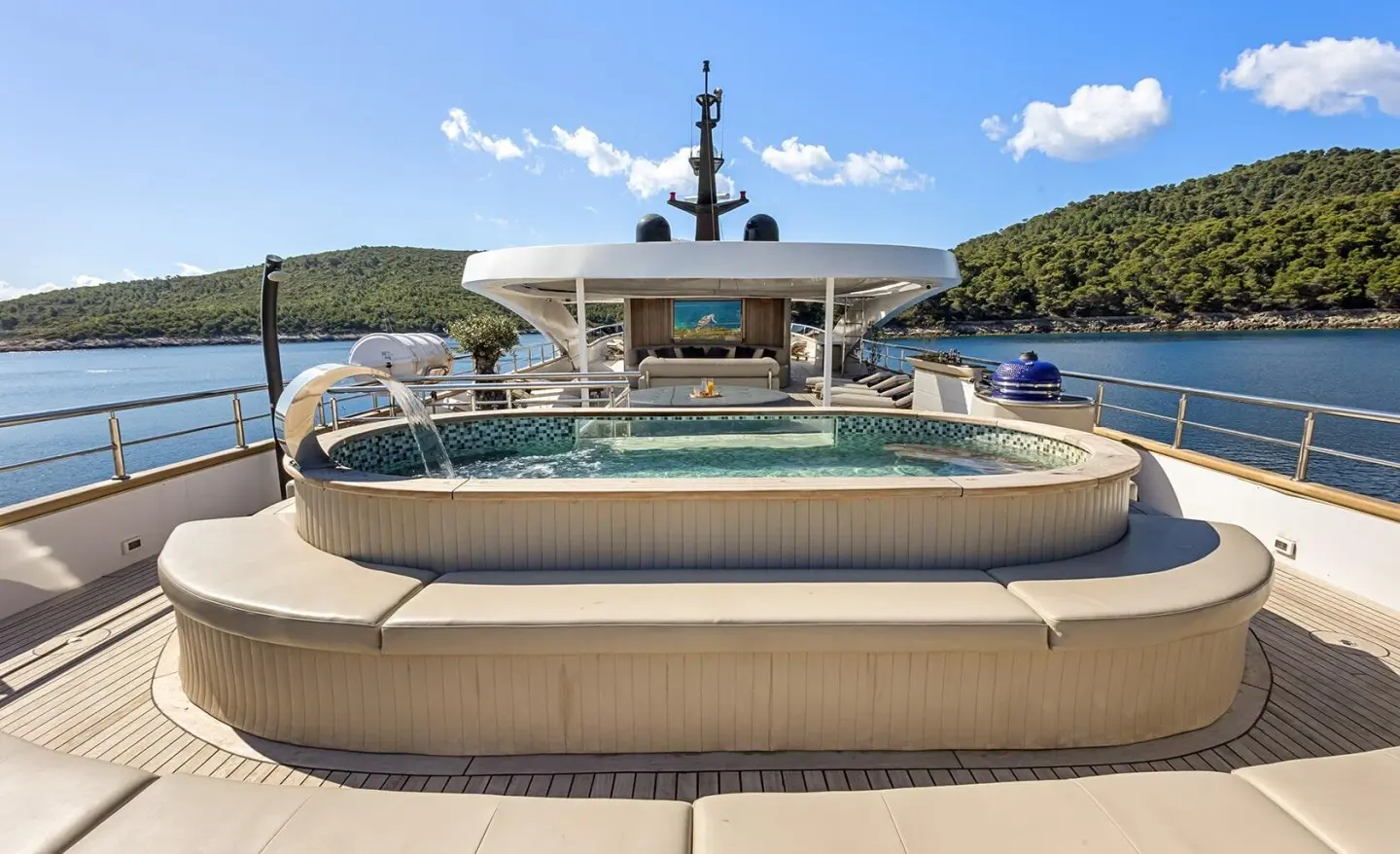 Bella yacht sun deck with curved jacuzzi and ocean backdrop