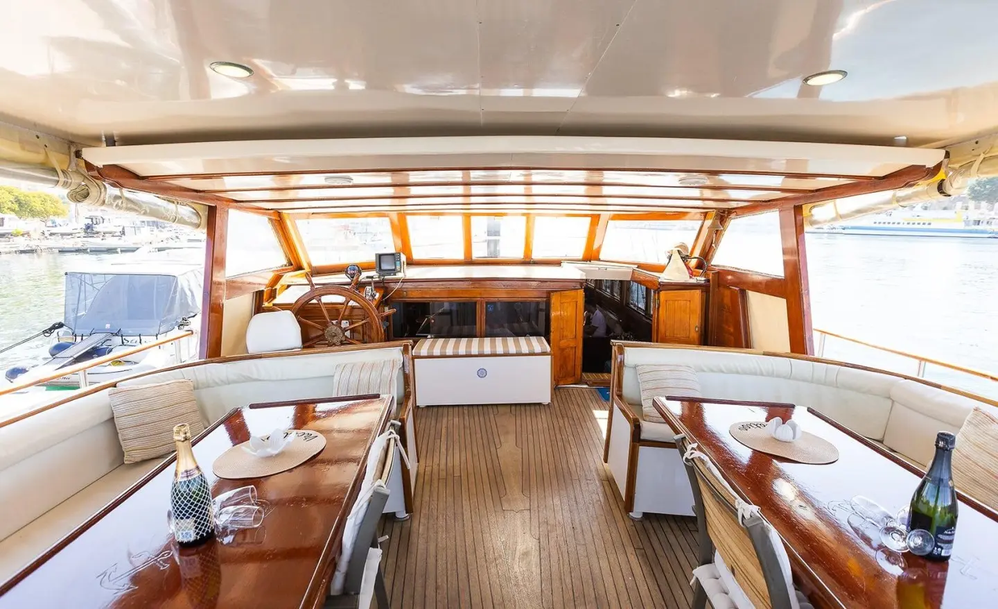 Luxurious yacht Gardelin cockpit with cushioned seating and warm wood interior at sunset
