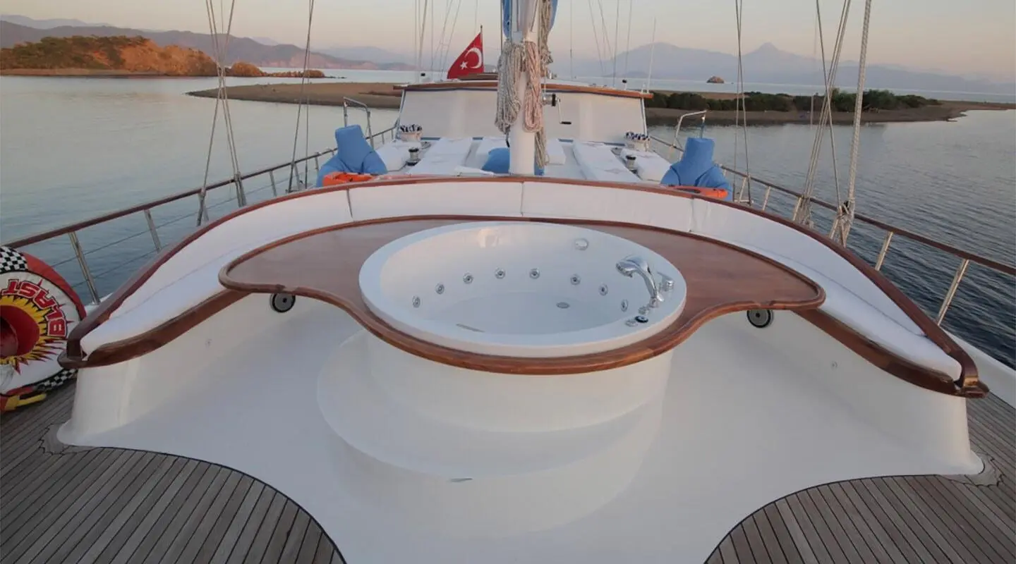atop a yacht deck with a circular white seating area and luxury rails at sunset
