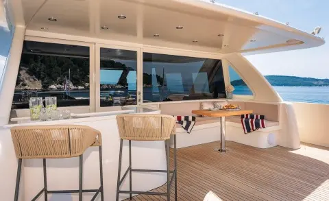 Grace yacht yacht charter: exterior seating area with table, chairs, and windows