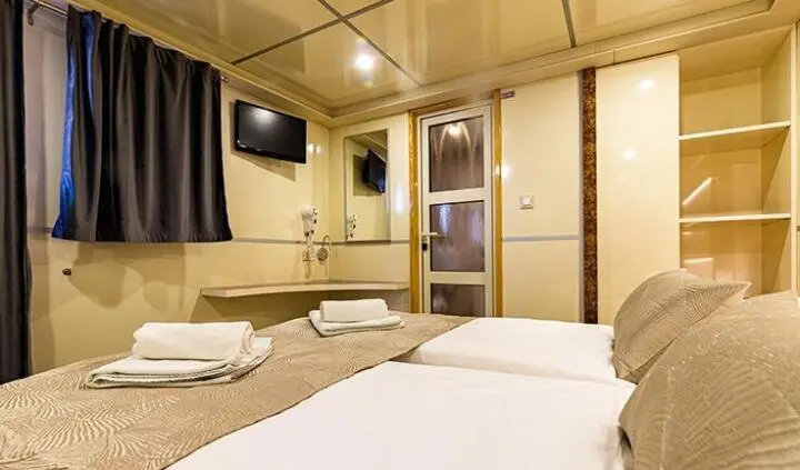Melody yacht master cabin with king bed and ensuite, wood paneling and windows