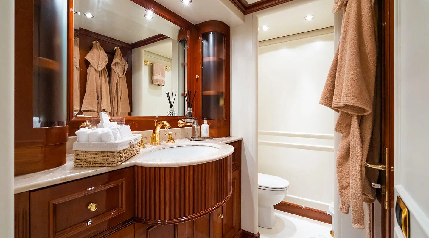 Amadea luxury yacht bathroom with wooden vanity, mirror, and white fixtures