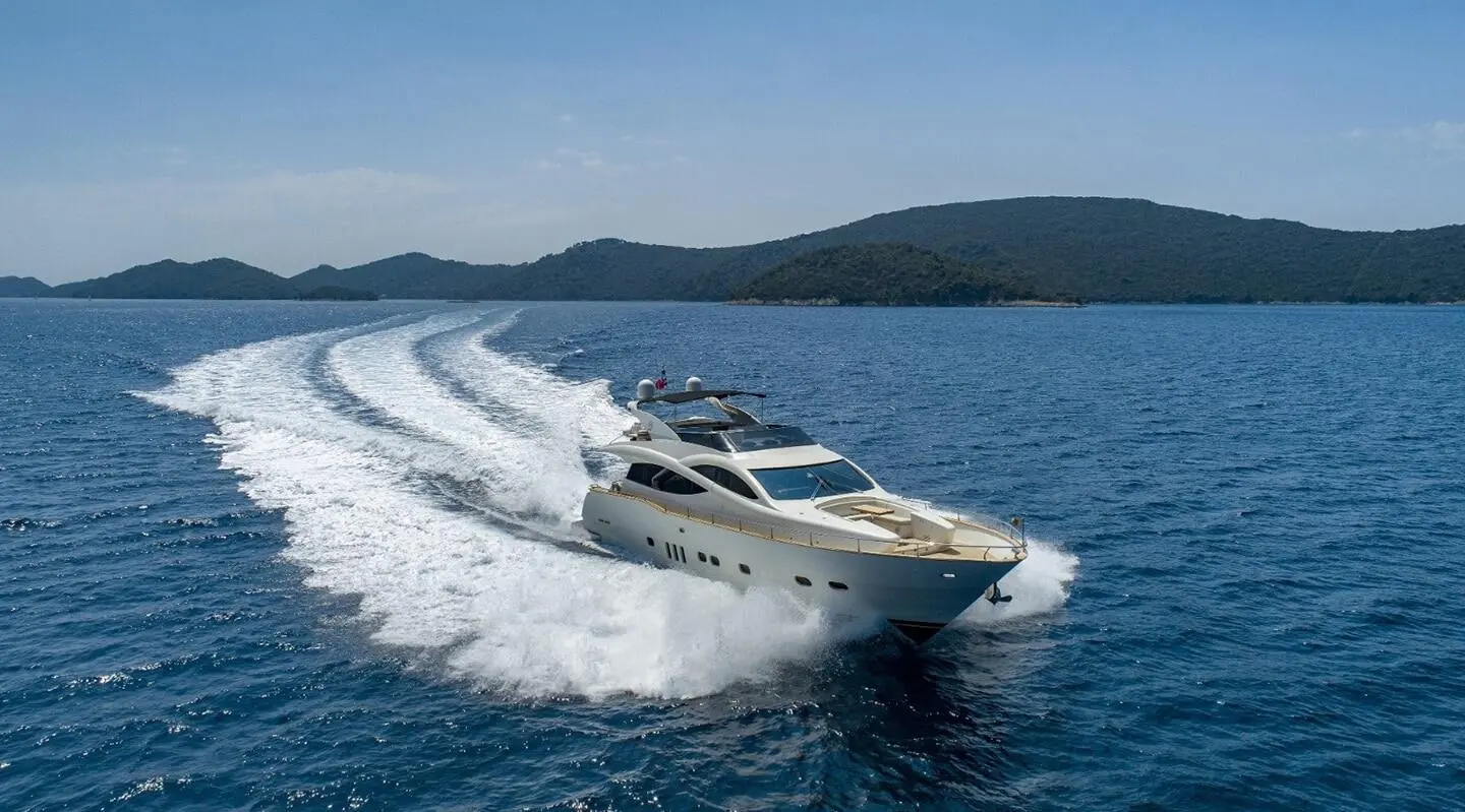 Luxurious motor yacht Salt cruising at speed, creating a white wake on blue sea