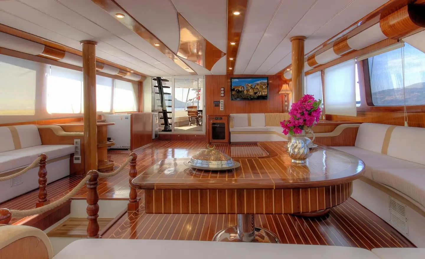 Angelo II luxury gulet deck at sunset with wooden seating and soft lighting