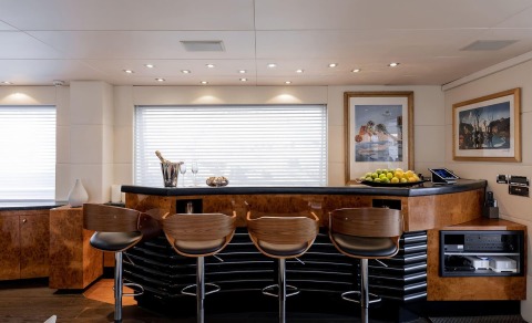 Brooklyn luxury yacht bar interior with polished wood counter and seating, fruit platter, champagne bucket