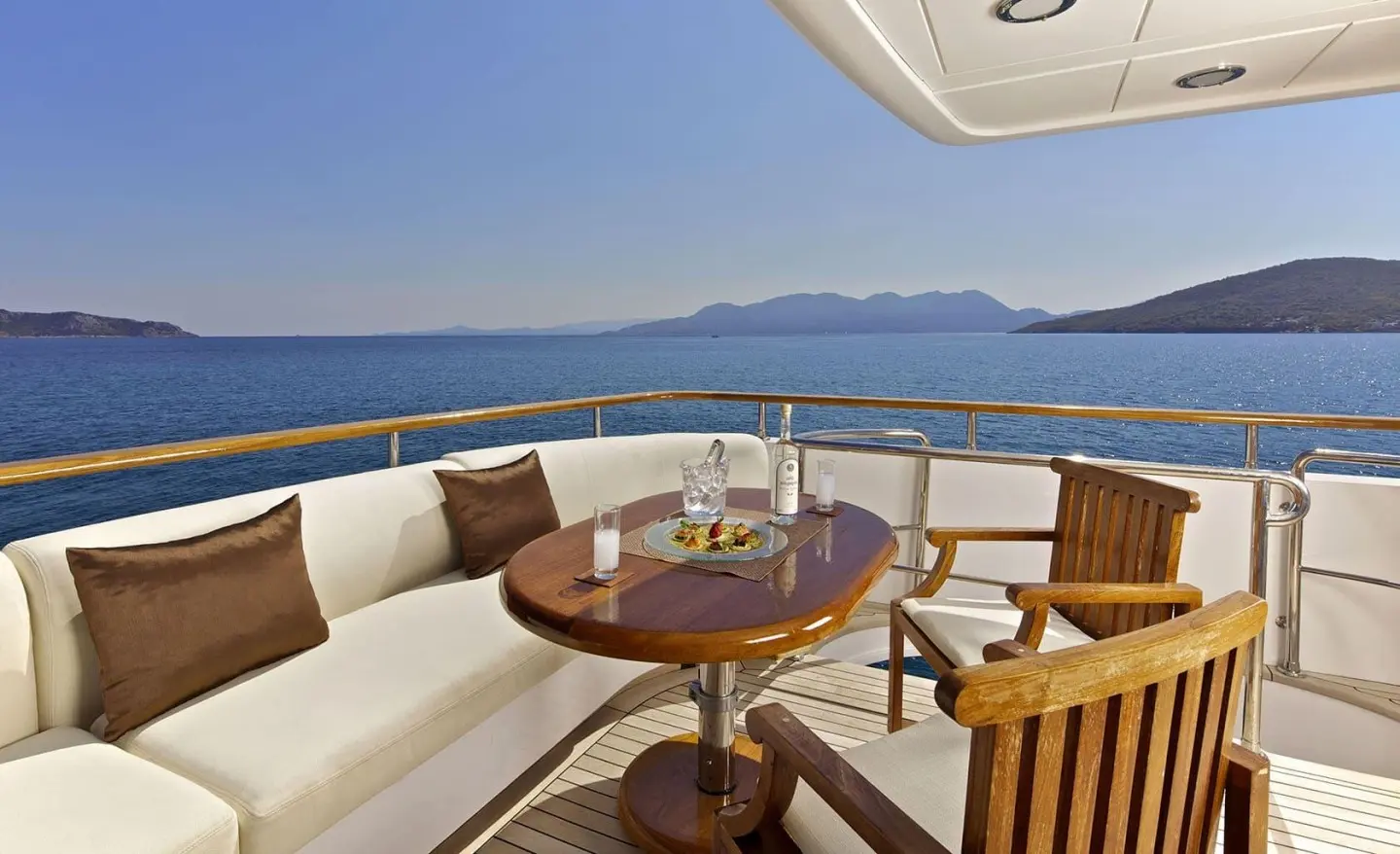 Luxurious yacht O'Rion deck seating and dining area overlooking blue sea