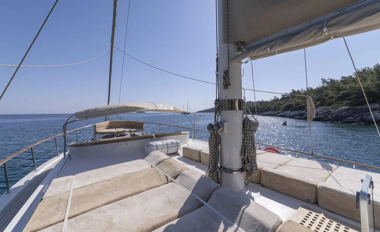 Sunset view from a luxury gulet, deck seating, ropes, and sails