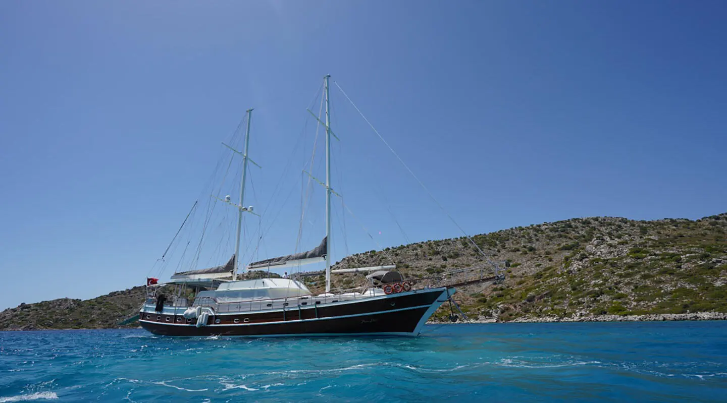 Prenses Esila classic sailing yacht anchored near rocky coastline in clear blue sea