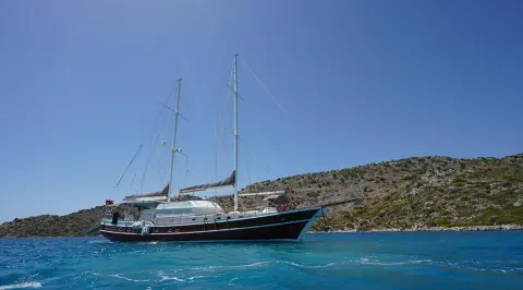 Prenses Esila classic sailing yacht anchored near rocky coastline in clear blue sea