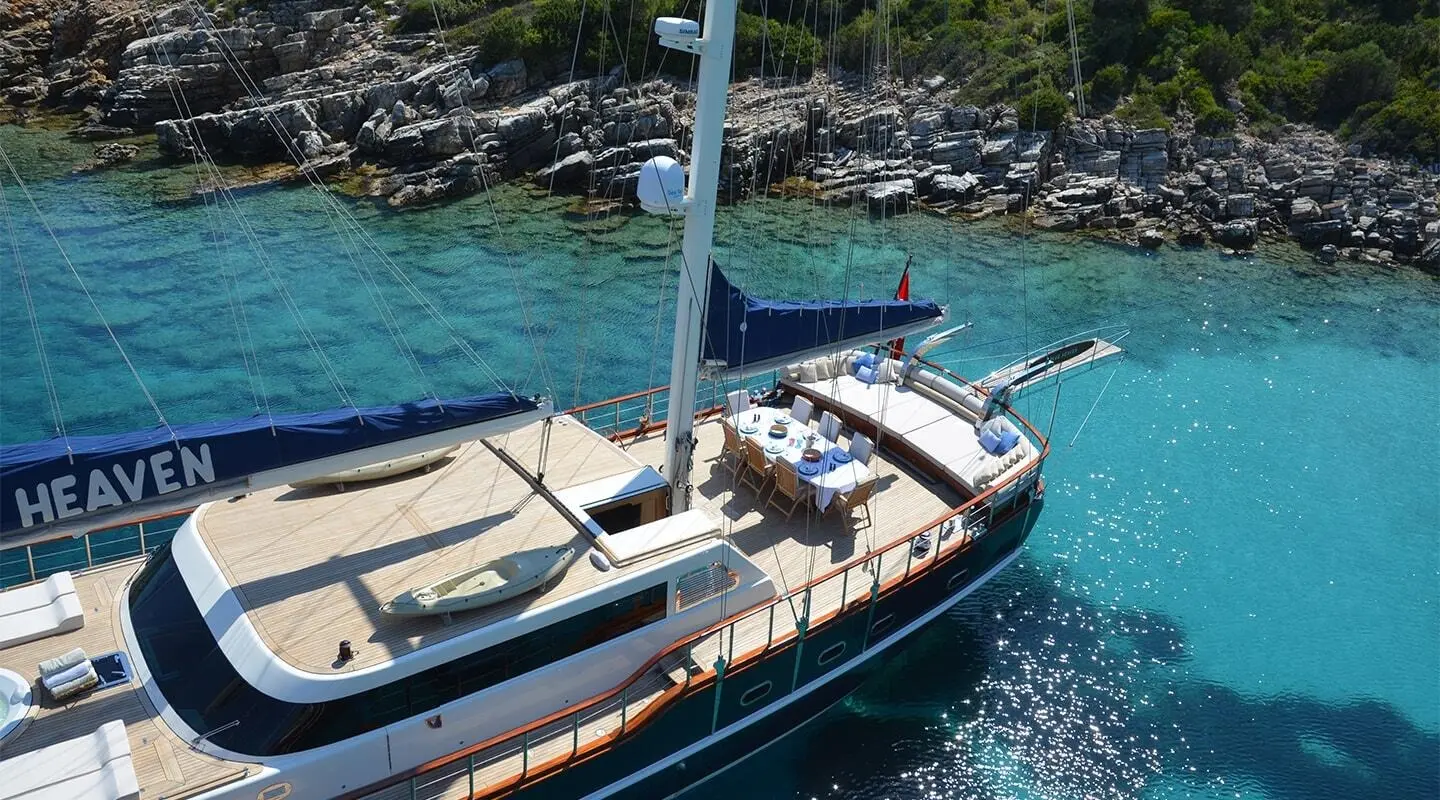 Gulet Blue Heaven sailing yacht anchored near rocky coastline and clear blue water