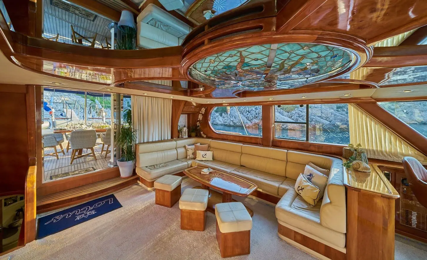 Gulet Lotus interior salon with curved wooden panels, seating, and large windows
