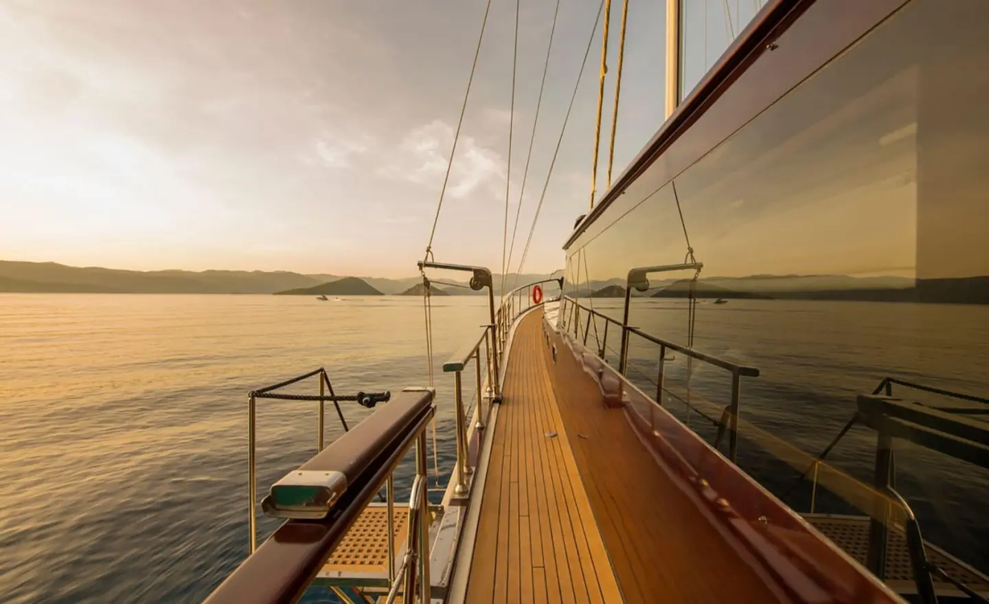 Sunset view along a luxury gulet with polished deck and railings