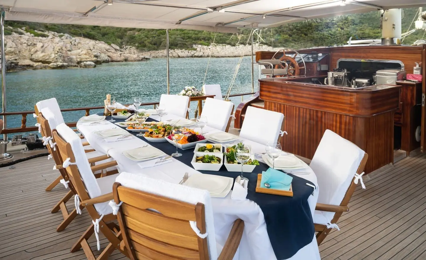 Yacht Estrella De Mar dining setup on deck with white tablecloths and chairs