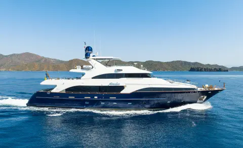 Amadea yacht cruising on blue sea with clear sky and distant coastline