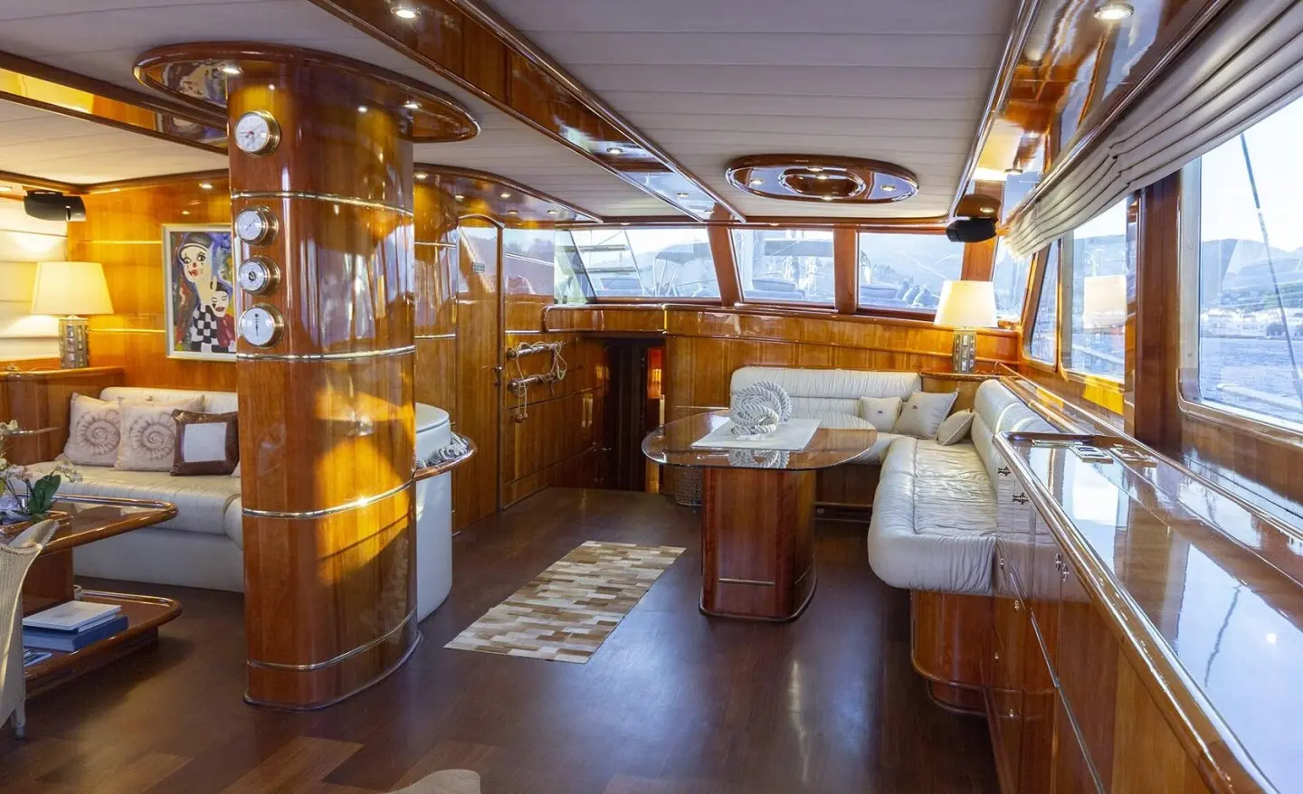 Interior of a luxury yacht salon with wood accents, seating, and warm lighting