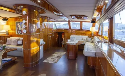 Interior of a luxury yacht salon with wood accents, seating, and warm lighting