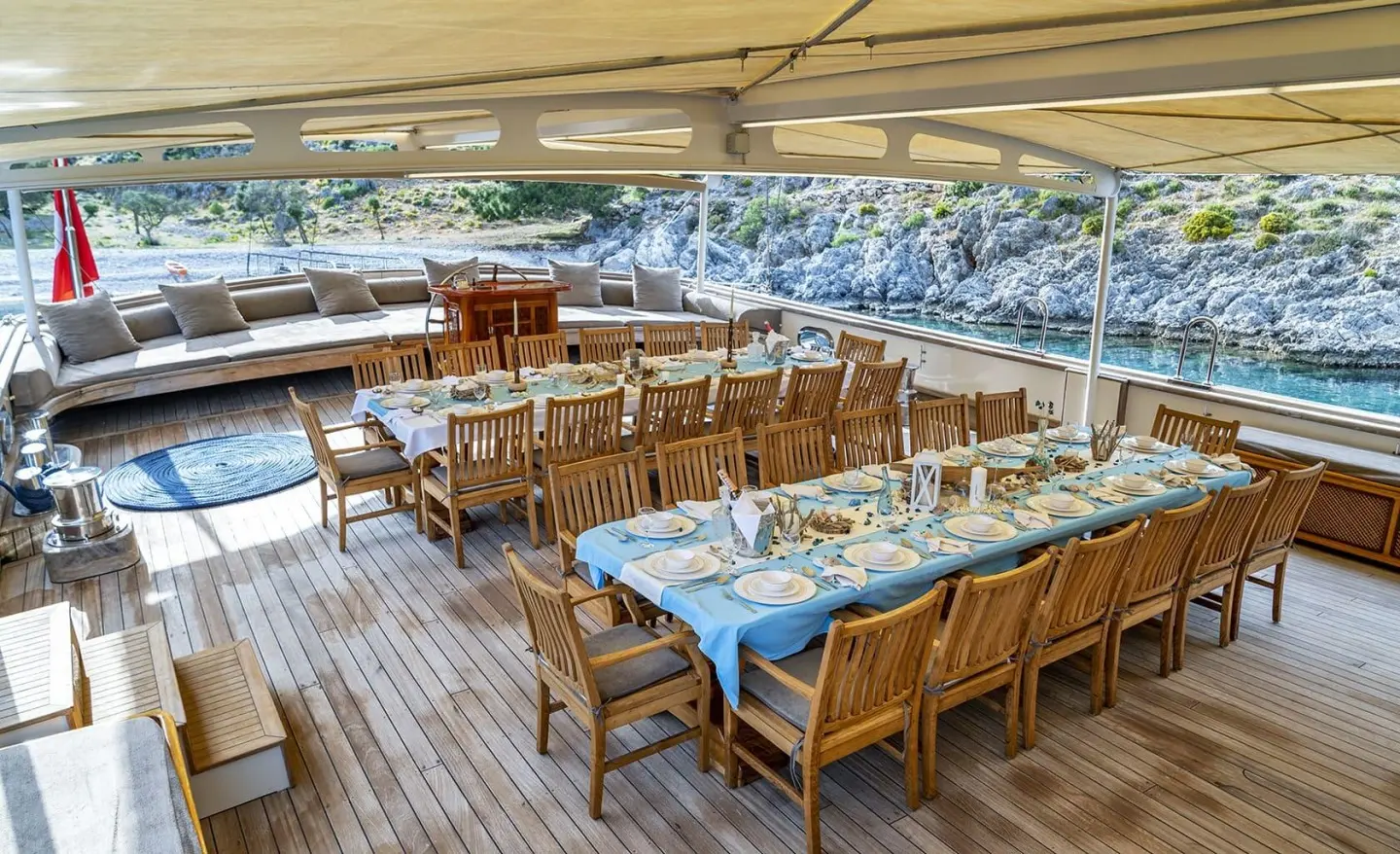 Gulet Tersane 8 aft deck dining table setup with wooden chairs under shade